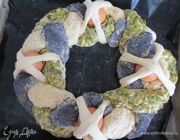 Из теста, которое мы отложили на украшения, сделать 8 тонких полосок. Равномерно размещаем 4 сырых яйца по нашей косе, каждое яйцо закрепляем двумя полосками теста, сложенными крем-накрест.
Оставить косу для расстойки на 20-30 минут.
Выпекать в разогретой до 180°С духовке в течение 50 минут до золотистого цвета.
Чтобы яйца не треснули, духовку во время выпечки нужно держать закрытой.

