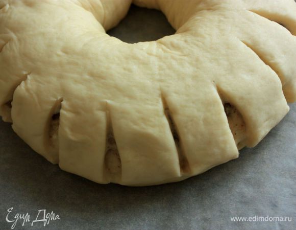 На внешней стороне сделайте надрезы через каждые 3 см до начинки длиной примерно 1/3 венка. Накройте венок влажным, хорошо отжатым полотенцем и оставьте подниматься в течение 45 минут.