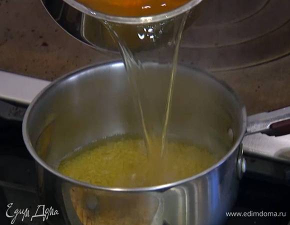 Кускус всыпать в кастрюлю, залить горячим овощным бульоном, добавить 1 ст. ложку оливкового масла, накрыть крышкой и варить 10‒15 минут до готовности.