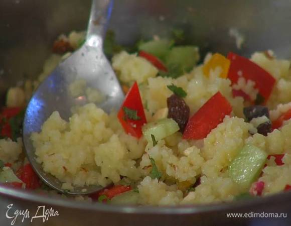 Готовый кускус размешать вилкой, добавить в кастрюлю оливки, курагу, изюм, огурец, сладкий и острый перец, мяту, измельченный миндаль и все перемешать.