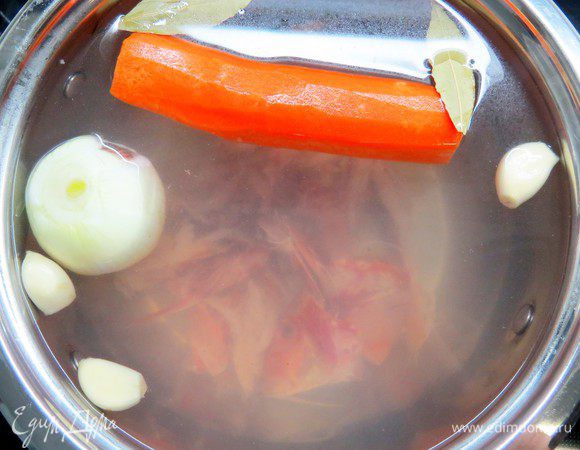 В кастрюлю налить воды (примерно 2,5 л), сварить бульон из рыбьих голов, хвостов, костей с остатками мяса с добавлением одной луковицы, одной моркови, двух зубчиков чеснока, лаврового листа, соли и перца. Бульон варить на медленном огне около 1 часа.
