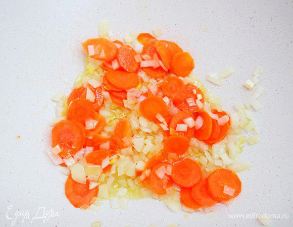 Разогреть в большой кастрюле масло, спассеровать лук, затем добавит морковь.