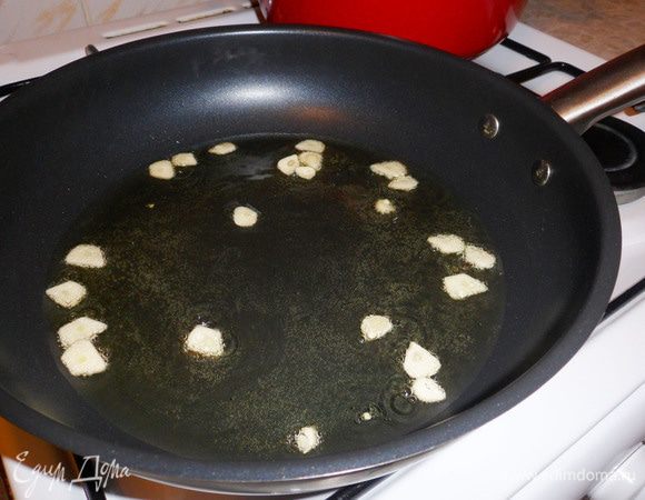 Обжариваем пластинки чеснока до золотистого цвета. Затем удаляем чеснок со сковороды.