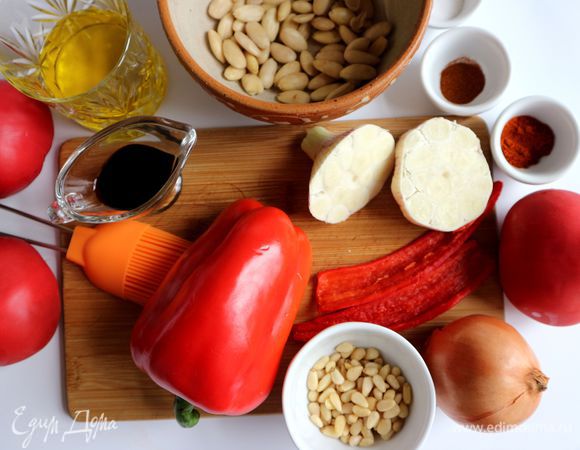 Духовку разогреть до 180°С. Чеснок разрезать поперек. Перец чили разрезать на половинки, освободить от семян.