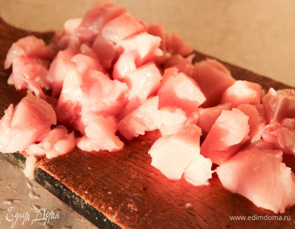 Аккуратно вынуть из птицы грудку, стараясь не повредить кожу. Вынуть кости, грудку нарезать кубиками. Сложить в миску.