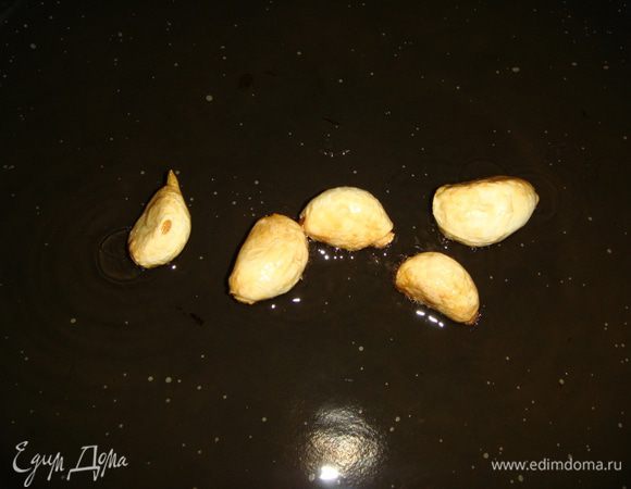 Сковороду нагреть, влить оливковое масло и положить очищенный чеснок. Обжарить чеснок до золотистого цвета и выложить.