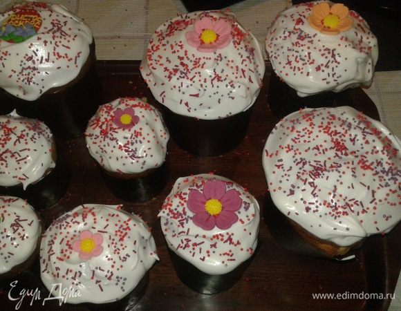 Даем остыть куличам и покрываем глазурью, для этого взбейте белок с 150 г сахарной пудры. Можете просто покрыть белой.