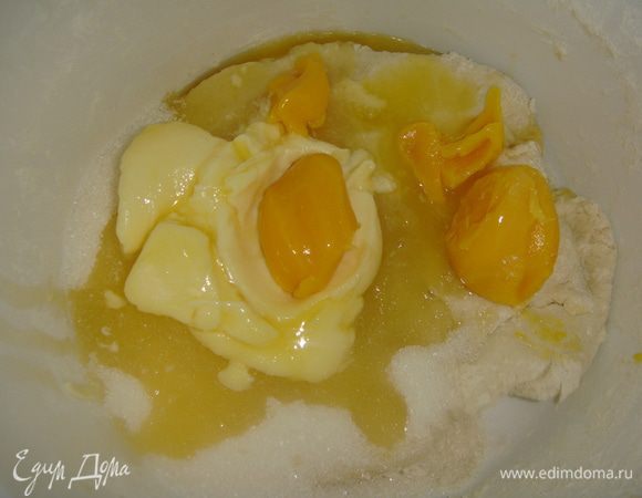Добавляем мягкое сливочное масло, яичные желтки и сахар. Замешиваем тесто руками или миксером с насадкой крюк. 