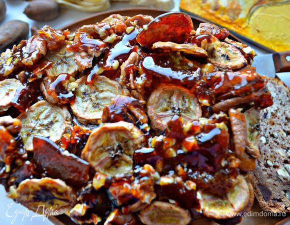 Готовый кекс смажьте сладкой водой (сиропом), выложите грильяж и кружочки банановых чипсов.