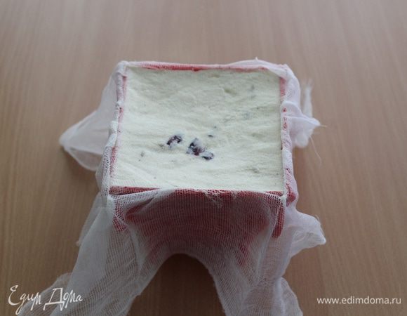 Пасочницу изнутри выкладываем марлей и плотно начиняем творожной массой. Сверху прикрываем краями марли, ставим небольшой груз сверху и отправляем на ночь в холодильник. 