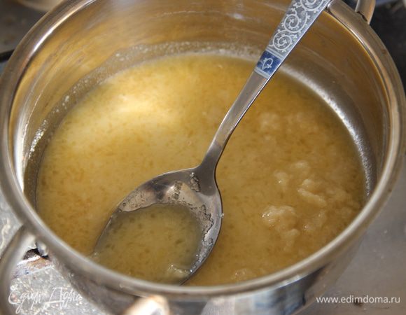 Добавить апельсиновый сок в массу, поставить на медленный огонь. Варить около трех минут, постоянно помешивая, пока не растворятся все комки, а масса не станет густой. 