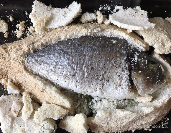 Корка из соли станет твердой, как кирпич. Постучите по ней ложкой, и корка должна отломиться одним куском. Уберите с рыбы соль, снимите оставшуюся кожу и переложите рыбу на блюдо при помощи широкой лопатки. Пройдитесь ножом вдоль позвоночника до головы и отрежьте голову. Приподнимите верхнее филе, чтобы рыба раскрылась, как книга. Выньте кости и подавайте рыбу.