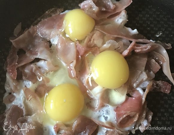 Когда хамон станет хрустящим, влейте яйца и жарьте пару минут, пока белки не потеряют прозрачность. Всыпьте в центр сыр и дайте ему слегка расплавится. Посыпьте тимьяном и свежемолотым черным перцем.