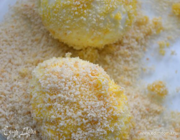Фаршированные яйца обмакнуть в яичную смесь и аккуратно обсыпать панировкой.