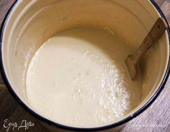 Добавляем сюда оставшееся молоко (теплое!) и 500 г муки. Хорошо размешиваем деревянной ложкой.