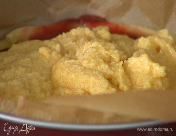 Подпеченный корж смазать малиновым джемом, затем выложить миндальную массу и равномерно распределить.