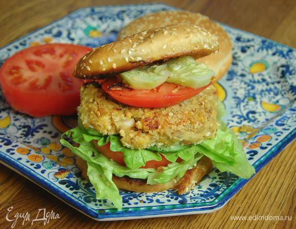 Обжаренные стороны булок сбрызнуть оливковым маслом Extra Virgin, выложить по листу салата и кружку помидора, затем еще салат и кусочек огурца, сверху поместить котлеты, по ломтику помидора и огурца, накрыть оставшимися половинками булок.