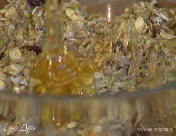 Всыпать овсяные хлопья, добавить изюм и мед, все вымешать.