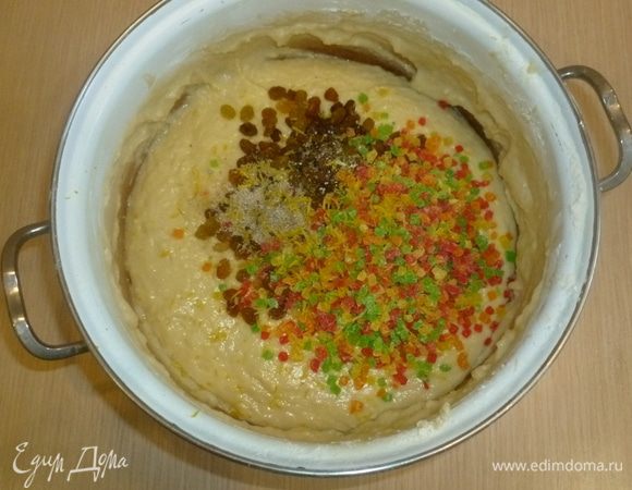 Добавить в тесто изюм, цукаты, кардамон, ванильный сахар и цедру лимона. Вымешивать тесто до гладкости и блеска. 