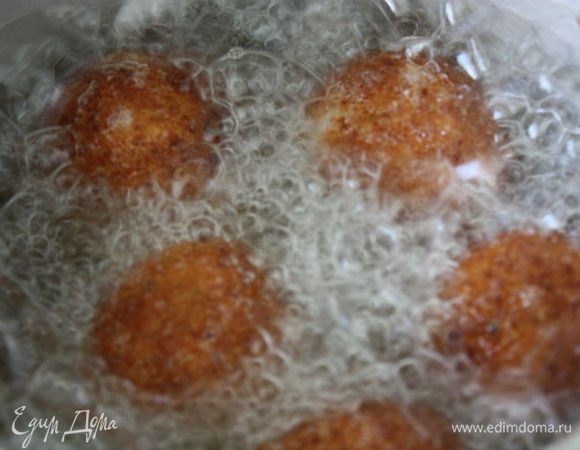 В глубокой сковороде нагрейте масло для фритюра до 180°C. Готовность его проверяется так: кубик белого хлеба в нем должен стать золотистым через 1 минуту. Не делайте сильным огонь во время жарки, иначе температура будет выше. Положите фрикадельки в сковороду и готовьте до золотистого цвета. 