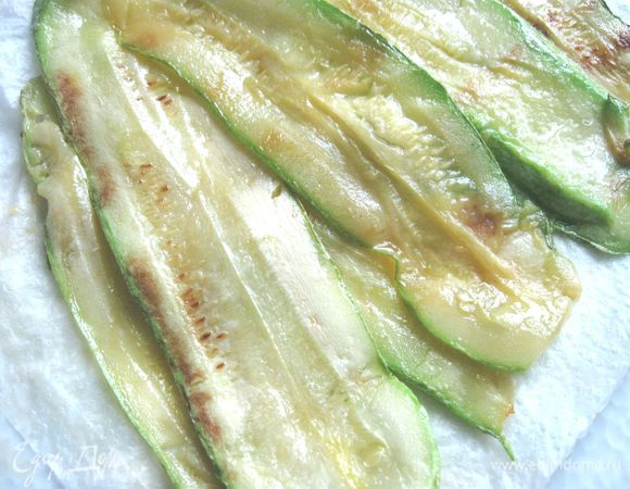 Разогреть сковороду с маслом, обжарить пластинки  кабачков, чтобы они стали эластичными. Положить затем на блюдо, покрытое бумажной салфеткой.