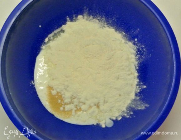 В кефир комнатной температуры  всыпать сухие дрожжи, 1 столовую ложку сахара и 2 столовые ложки муки. Размешать, оставить на 15–20 минут.