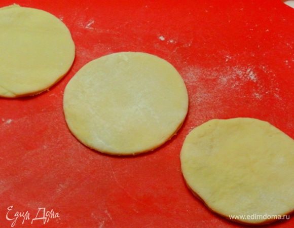 Для оформления верха тесто, которое откладывали, раскатать. Вырезать 5 кружков диаметром 10 см — для большого кулича, и 3 кружка диаметром 7 см — для маленького кулича.