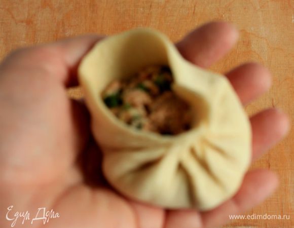 Большим и указательным пальцами правой руки делать защипы по кругу , подтягивая тесто к центру начинки. При этом подушечка большого пальца остается на одном месте. Мне очень помогло видео! Ссылки здесь давать нельзя, поэтому  только рекомендую набрать в поисковике запрос: 1/2 How to Make Skin and Wrap Baozi Steam Buns . Там очень доходчиво показано. В центре должно остаться маленькое отверстие. Я не смогла одной рукой сделать четкое фото.