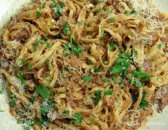 В кастрюлю, где томился кролик с овощами, влить оставшееся оливковое масло, выложить рагу и лапшу, перемешать и немного прогреть, затем выложить в блюдо, посыпать петрушкой и сыром.