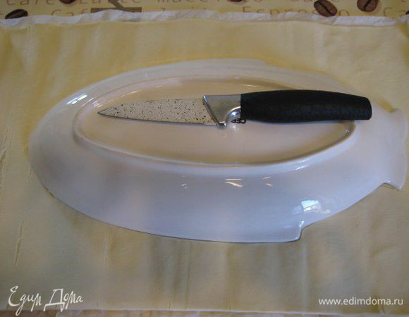 Пласт слоеного теста вместе с бумагой для выпечки выложить на противень, вырезать рыбу шаблоном, я воспользовалась тарелкой в форме рыбы. 