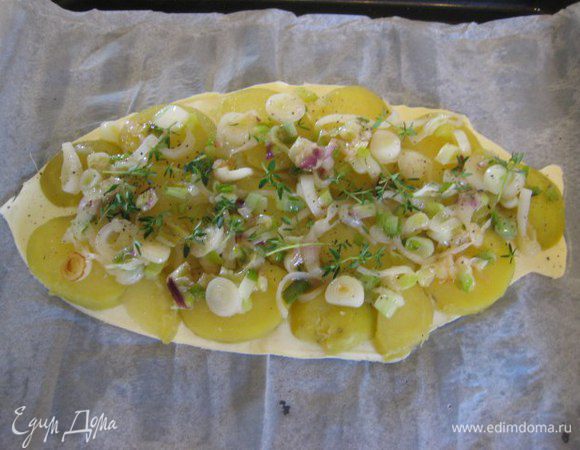 На тесто выложить в один слой картофель, сверху лук, посыпать листиками тимьяна, посолить, поперчить.