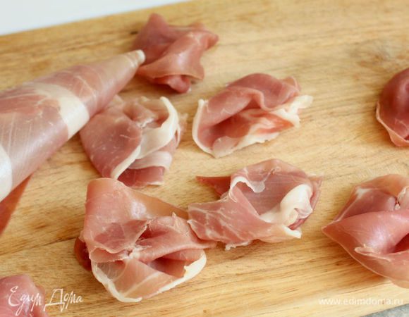 Моцареллу нарезать кружочками. Ломтики ветчины разрезать вдоль и собрать в «клубочки».
