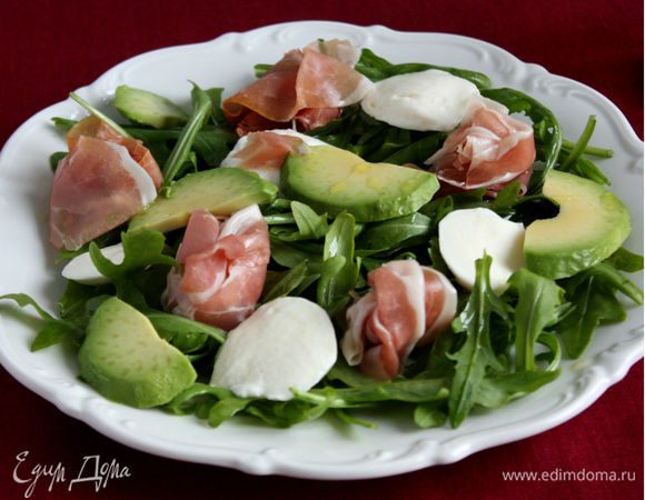 Сверху на руколу поместить моцареллу, ветчину, ломтики авокадо. Полить оливковым маслом, приправить солью и перцем .