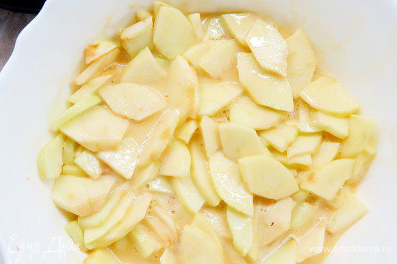 Кладем нарезанные яблоки в тесто. Теста должно быть почти и не видно, оно должно равномерно распределиться между кусочками яблок.