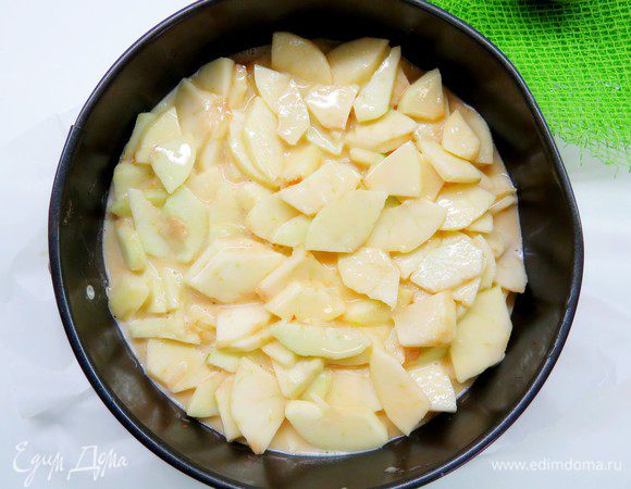 Форму диаметром 20 см застелить бумагой для выпечки и вылить тесто с яблоками. Выпекать в разогретой духовке 25–30 минут при температуре 200°C. Пирог готов, когда на ощупь он достаточно твердый.