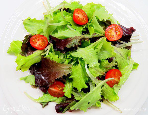 Салат помыть, обсушить, порвать руками и выложить в салатник. У меня была готовая салатная смесь, рвать руками не пришлось. На салат выложить порезанные на половинки помидоры черри.