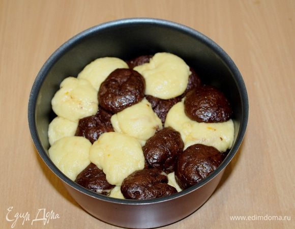 Каждую часть теста разделите на небольшие шарики. Выкладывайте шарики теста, чередуя их друг с другом, слегка приминая рукой в форме. 