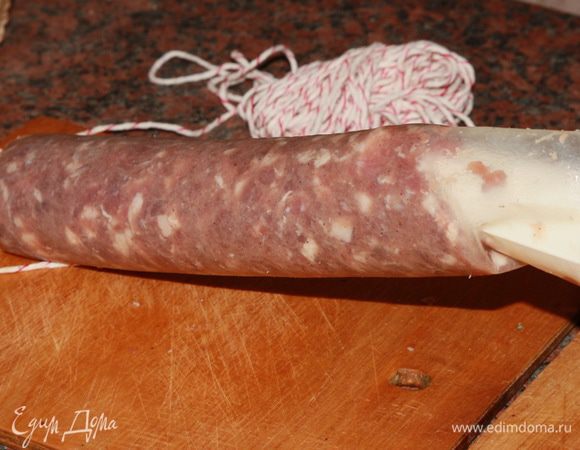Далее все, как обычно: колбасным шнуром завязываем один конец оболочки и через насадку наполняем ее фаршемассой. Точно также поступаем и со свиными кишками.