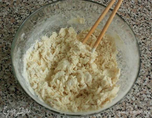 Муку просеять в миску, добавить соль и кипяток. Быстро перемешать и делать это лучше палочками или вилкой, но не ложкой, чтобы избежать образования комков. 