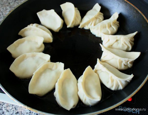 Нагреть большую сковороду и влить 1 ст. л. растительного масла, положить дим самы и обжарить на среднем огне до золотистого цвета с одной стороны.
