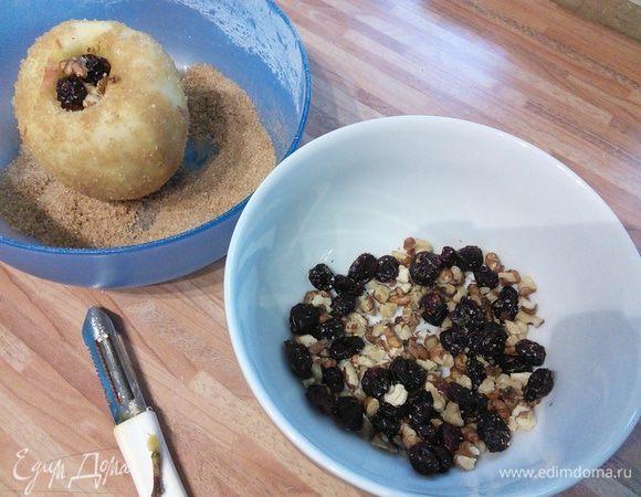 Для начинки смешать сахар с корицей. Подготовить клюкву и нарубить орехи. Яблоки очистить от шкурки, вынуть сердцевину с перепонками. Удобно воспользоваться для этого специальным ножом для очистки кожуры. «Хвостики» не выбрасывать. Постараться, чтобы донышко яблока осталось целым. Каждое яблоко обвалять в смеси сахара с корицей. 