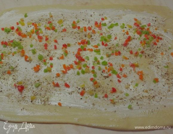 Размазать масло по всему пласту теста, распределить цукаты и молотый миндаль.