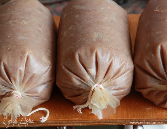 Далее начиняем оболочку фаршемассой любым доступным образом. Опять же, дома у меня нет специального шприца, поэтому я начала заполнять оболочку с помощью мясорубки и насадки, но это было медленно и неудобно. Поэтому я взяла столовую ложку и наполняла потом ею, ведь диаметр оболочки это позволяет. Время от времени поджимала фаршемассу, скручивая плотно концы. У вас будут пузырьки воздуха, это не страшно. Это происходит потому, что у нас не вакуумный шприц, а более примитивный способ наполнения. Прокалывайте густо тоненькой иглой. У меня получилось три небольших батончика по 380 граммов веса каждый.