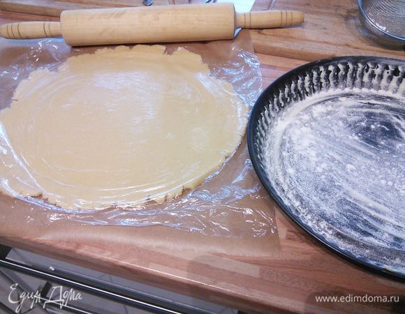 Тесто раскатать на пергаменте. Переложить в форму для тарта (бумагой кверху), смазанную маслом и посыпанную мукой. 