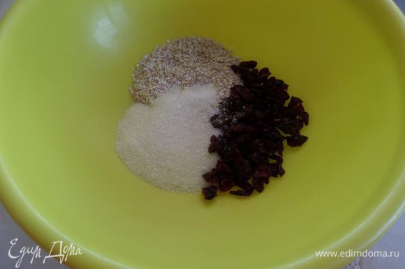 В чашку выкладываем сахар, овсяные отруби, щепотку соли и вяленую клюкву. Перемешиваем сухой ложкой.