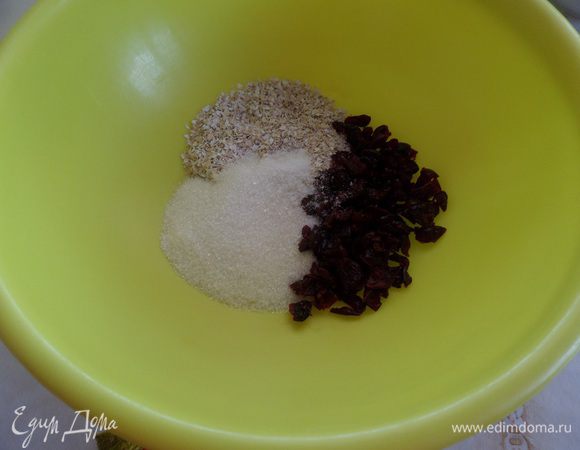 В чашку выкладываем сахар, овсяные отруби, щепотку соли и вяленую клюкву. Перемешиваем сухой ложкой.