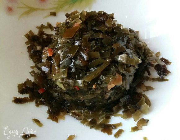 Из банки с морской капустой сливаем всю воду и перекладываем капусту в салатник.