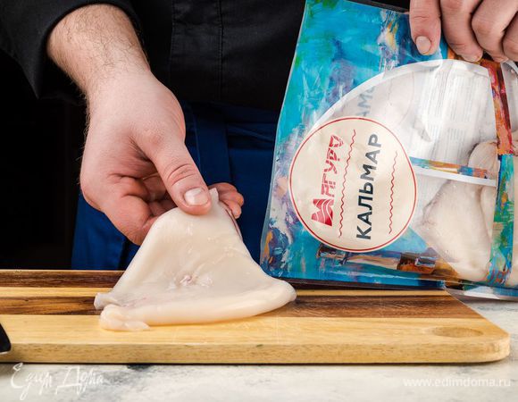 Кальмары ТМ «Магуро» почистите, вымойте и просушите бумажным полотенцем. Очень острым ножом сделайте на тушке каждого кальмара надрезы вдоль и поперек, чтобы получились клеточки.