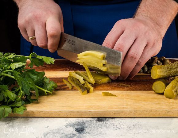 Приготовьте маринад. Огурцы мелко нарежьте, измельчите петрушку и укроп, крупно нарежьте каперсы. 