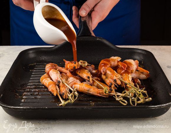 Готовые креветки еще на горячей сковороде смажьте соусом барбекю. И снова верните на огонь на 2 минуты.